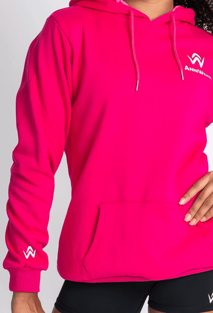 Person wearing a bright pink hoodie with a logo on a light gray background