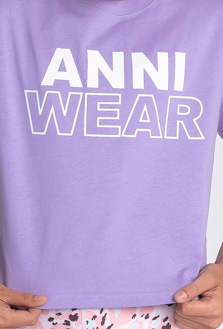 Purple shirt with 'ANNI WEAR' text held by hands