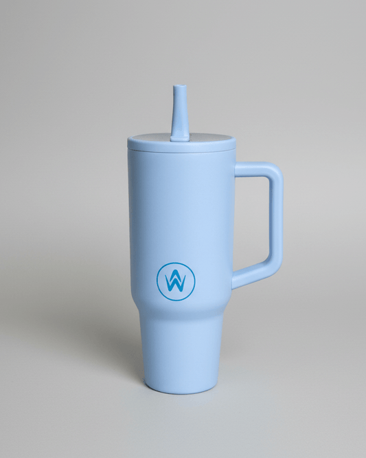 Light blue tumbler jug with handle and straw on a gray background