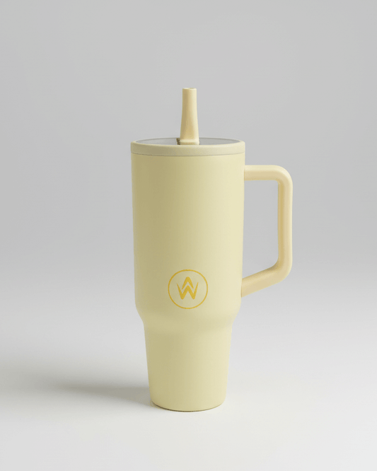 Lemon tumbler mug with handle and straw on a light gray background