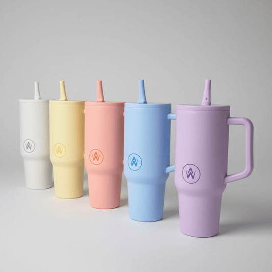 Set of five pastel-colored tumblers with straws on a gray background
