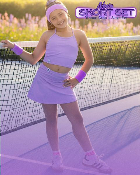 Girl in purple sports outfit standing on a tennis court with 'Novie' branding.