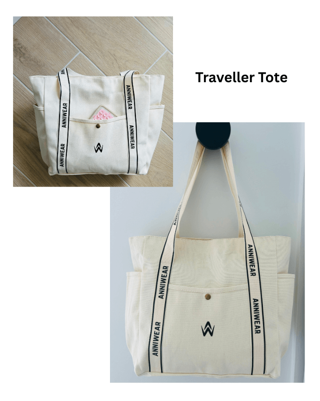 White tote bag with black text and logo on a tiled floor and white wall background.