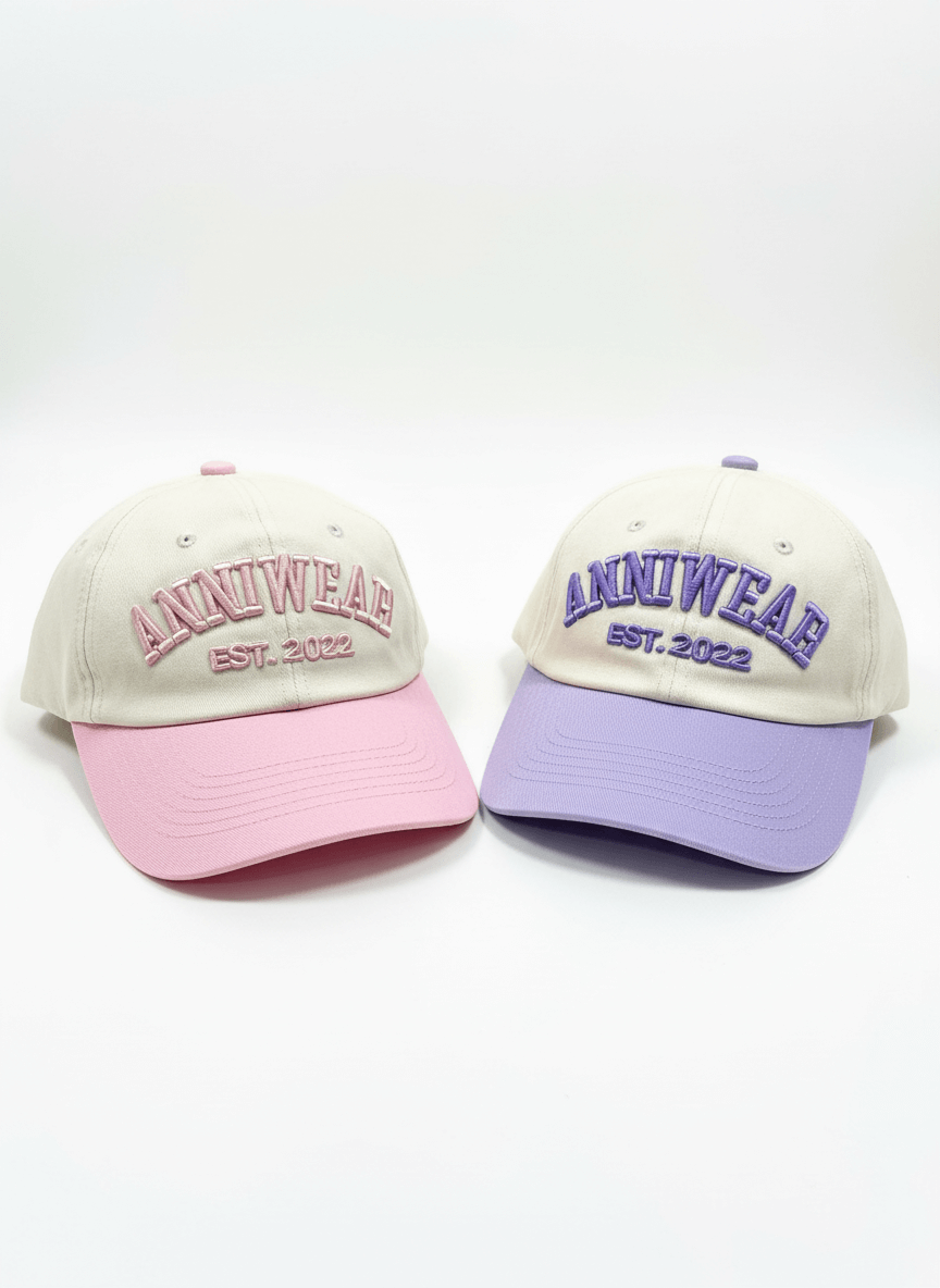 Two baseball caps with 'ANNIWEAR' branding on a white background