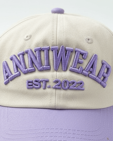 Beige and purple cap with 'ANNIWEAR EST. 2022' text on a light gray background