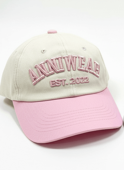 Beige and pink cap with 'ANNIWEAR EST. 2022' text on a white background