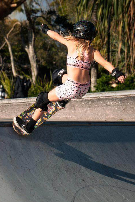 Person skateboarding on a concrete ramp with another person in the background.