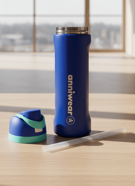 Blue water bottle with green cap and straw on a wooden surface