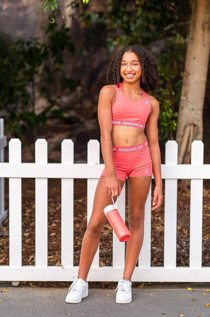 Coral athletic sports top and shorts with 'ANNIWEAR' branding on a white background
