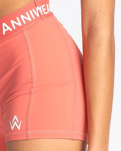 Coral athletic shorts with 'ANNIWEAR' branding on a white background