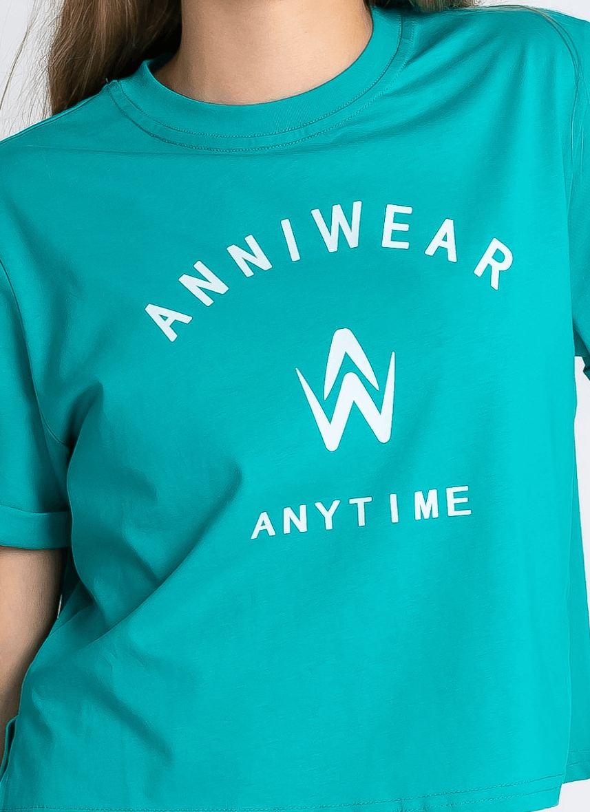 Teal t-shirt with 'ANNIWEAR ANYTIME' text and logo on a plain background
