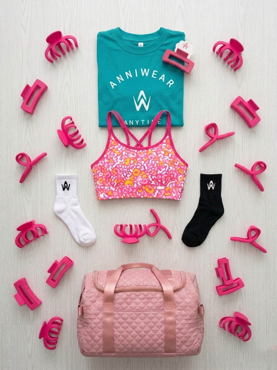 flat lay design of the tee, crop, shorts, socks, hair clip and a duffel bag.