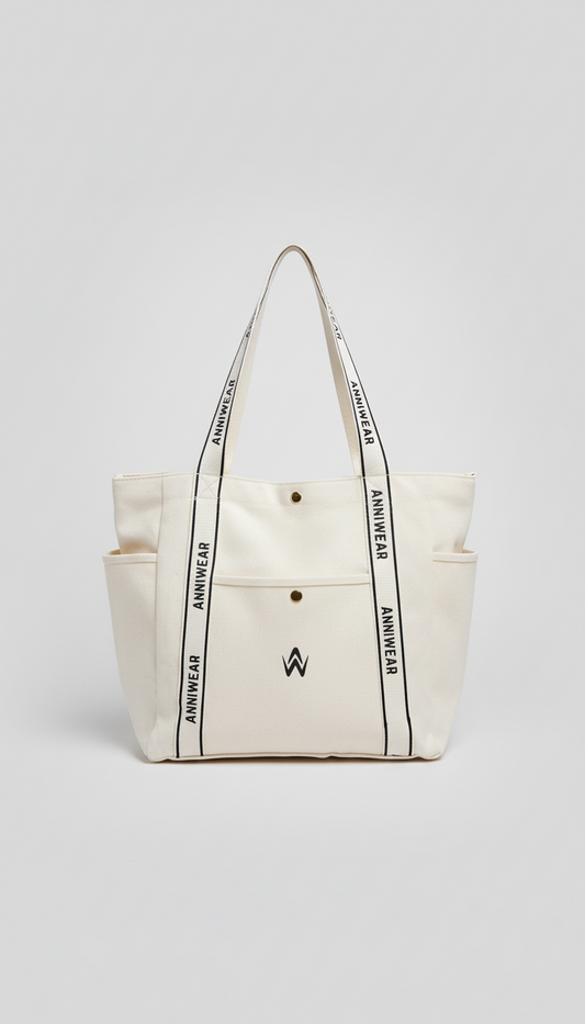 Beige tote bag with black text and a logo on a light gray background