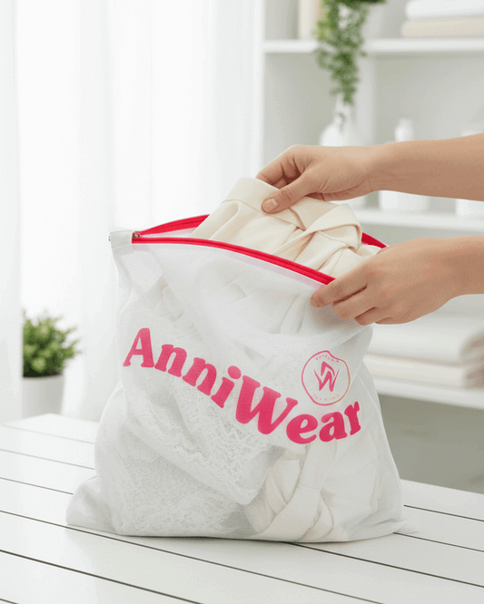 Person holding a white laundry bag with red zipper and 'Anniwear' branding on a light wooden surface.