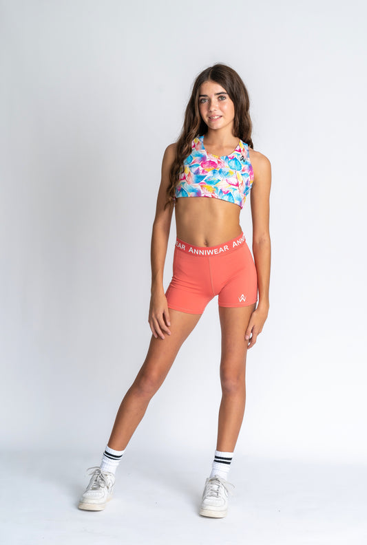 Sports Bra top with tropical floral design and Coral athletic shorts with 'ANNIWEAR' branding on a white background