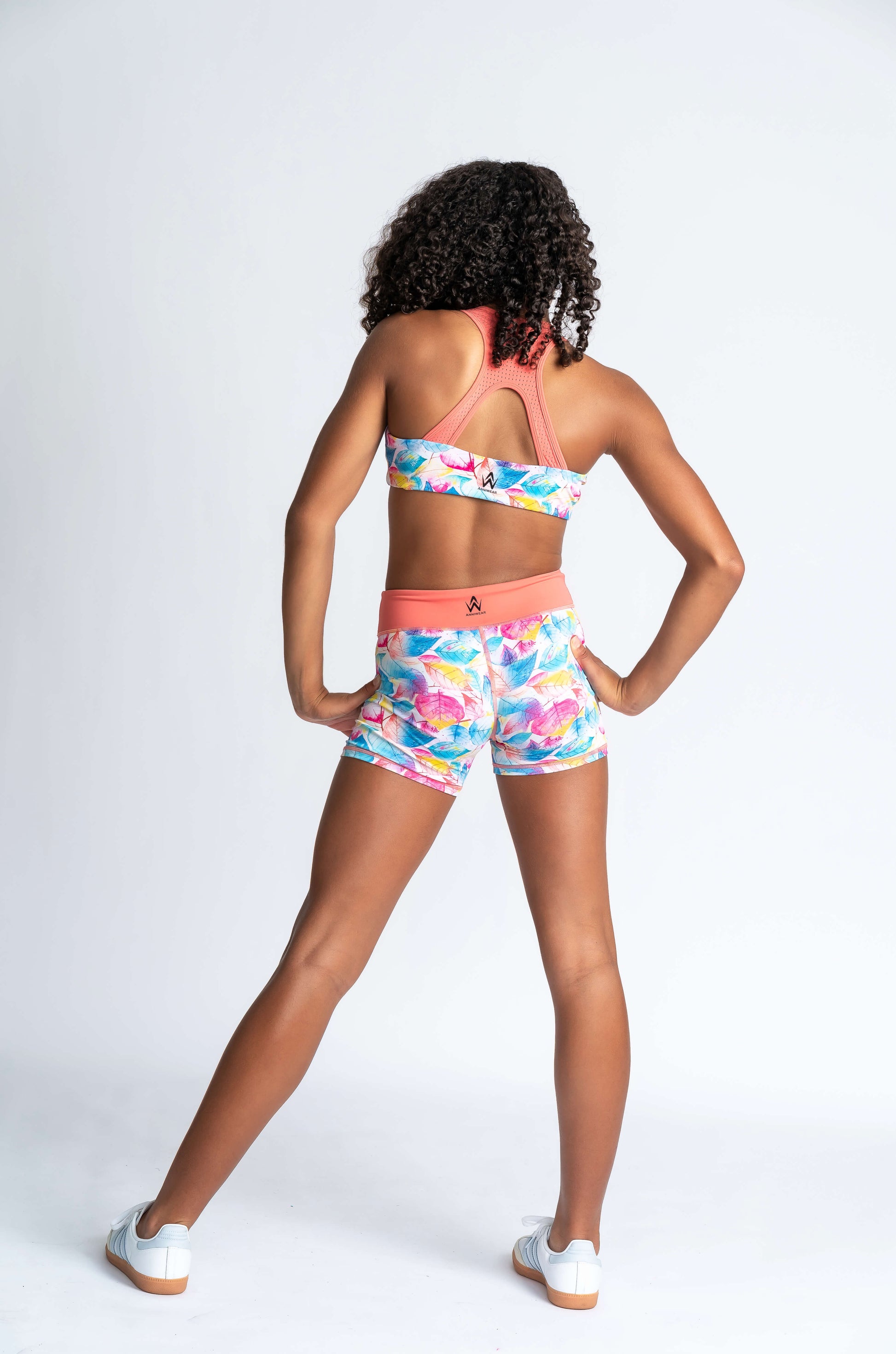 Coral and Tropical Leaf print sports bra and shorts set on a white background