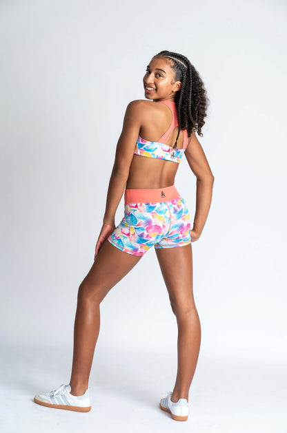 Tropical leaf-patterned crop and shorts with a brand logo on a white background