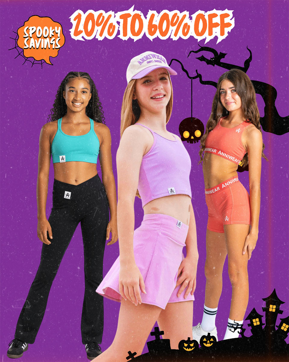 Three young women modeling matching athletic wear in turquoise, light purple, and coral colors, posed against a purple Halloween-themed background with '20% TO 60% OFF' text and 'Spooky Savers' branding.