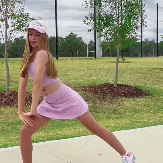 girl wearing a lilac skort activewear while stretching