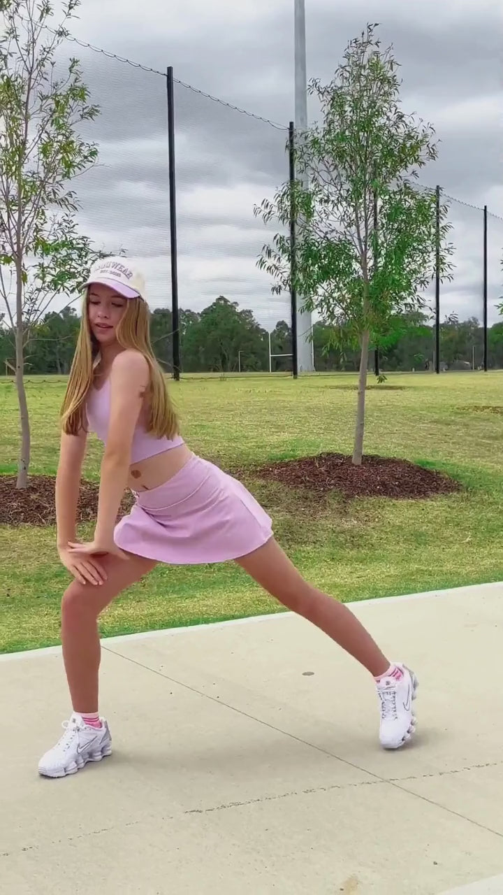 girl wearing a lilac skort activewear while stretching