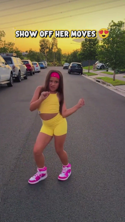girl dancing while wearing a yellow activewear set on the road